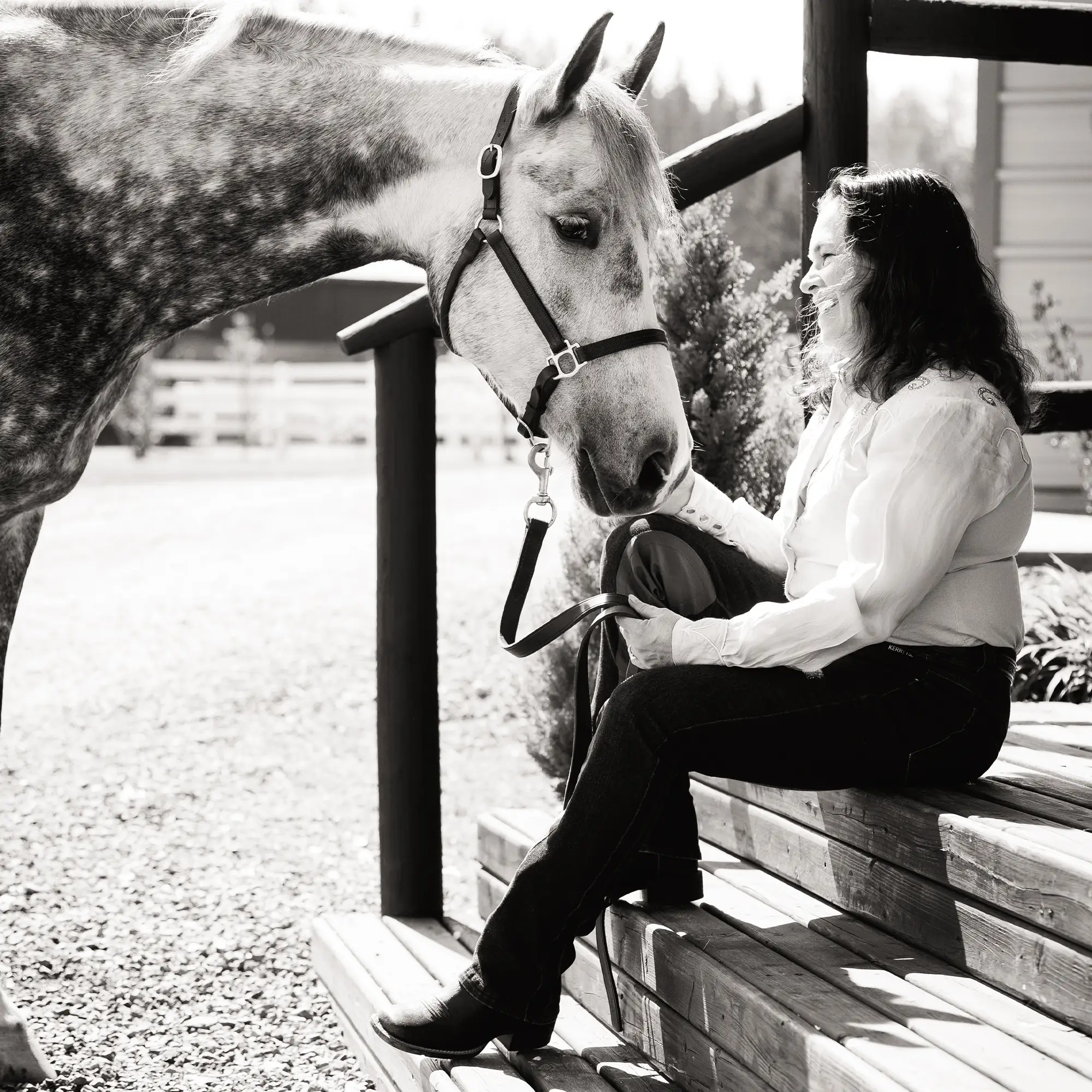 Jennifer Rader with her horse Ghost Whisperer sitting on steps, face to face